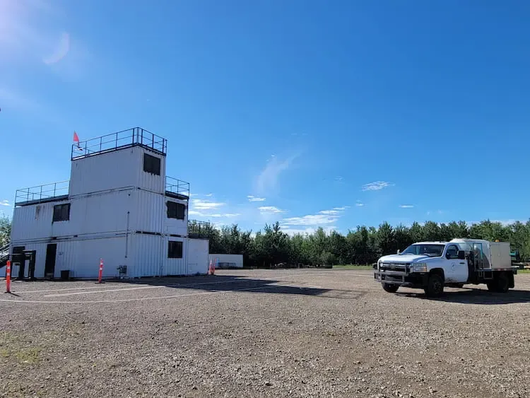 Two Green Oasis Gator vehicles in tall vegetation